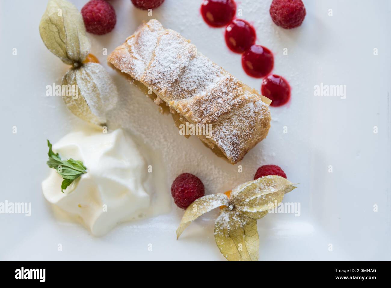 Apple strudel - delicious fruit cake with fruits and whipped cream Stock Photo