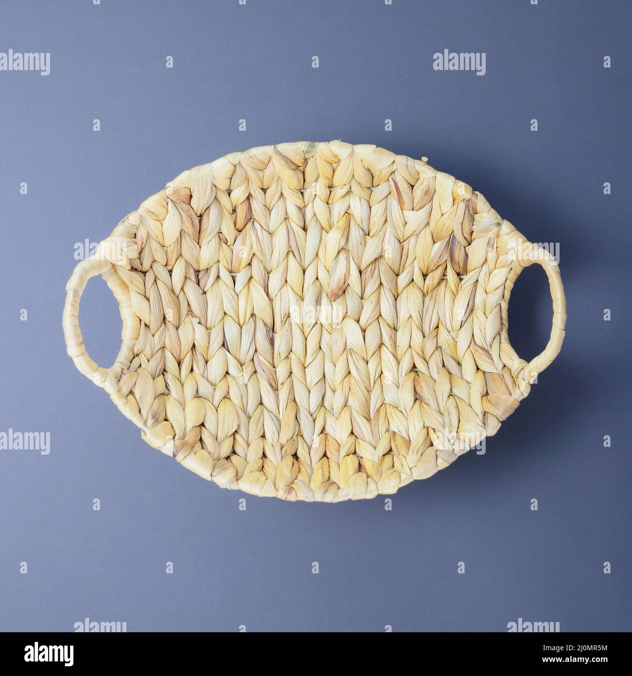 Beautiful wicker oval vase on a matte gray background. Top view. For fruit Stock Photo