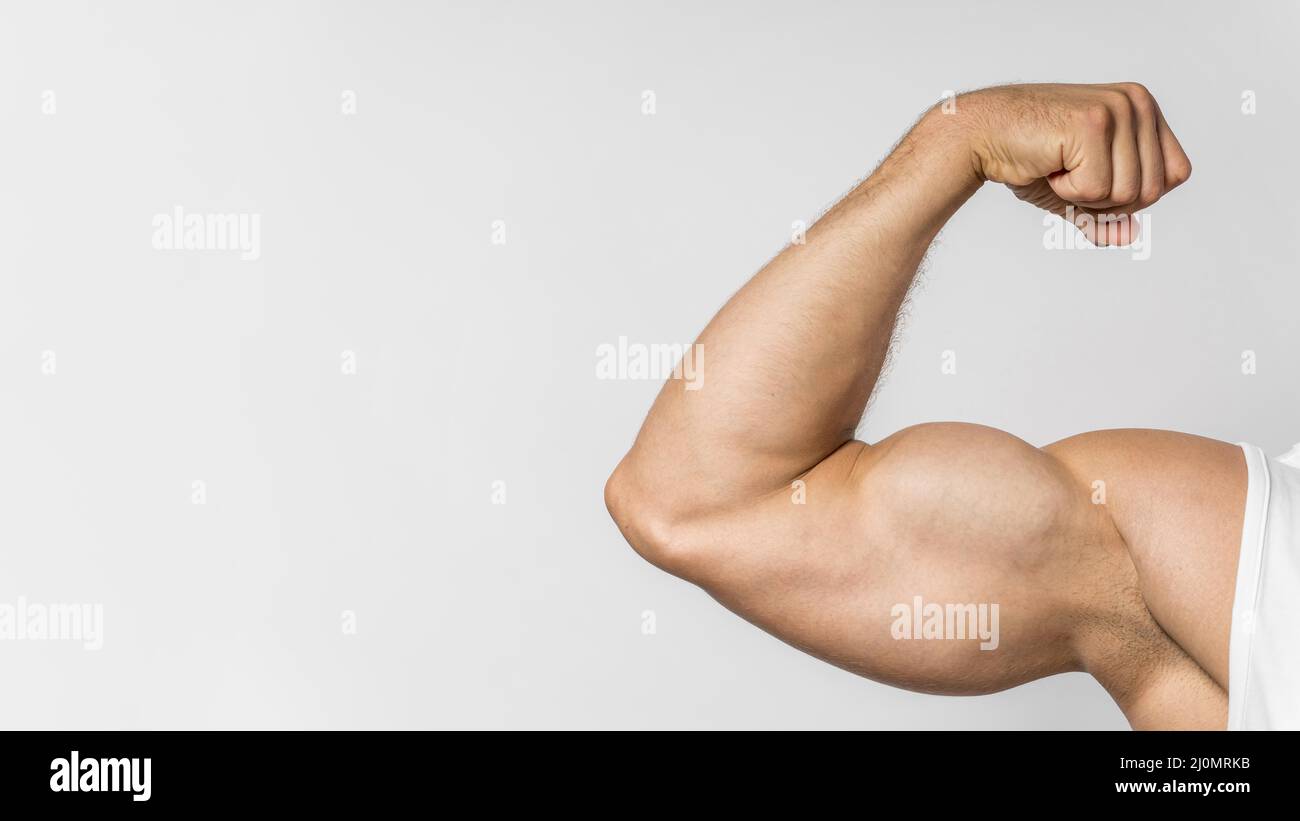Front view fit man showing bicep with copy space Stock Photo - Alamy