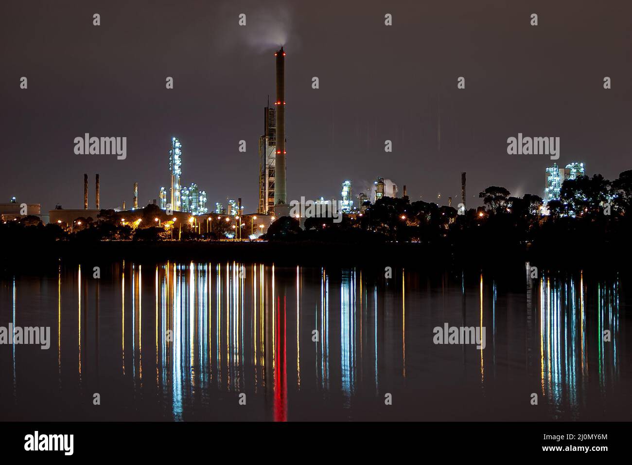 Night lights from factory refinery reflecting in blurry streaks on the Yarra river Stock Photo