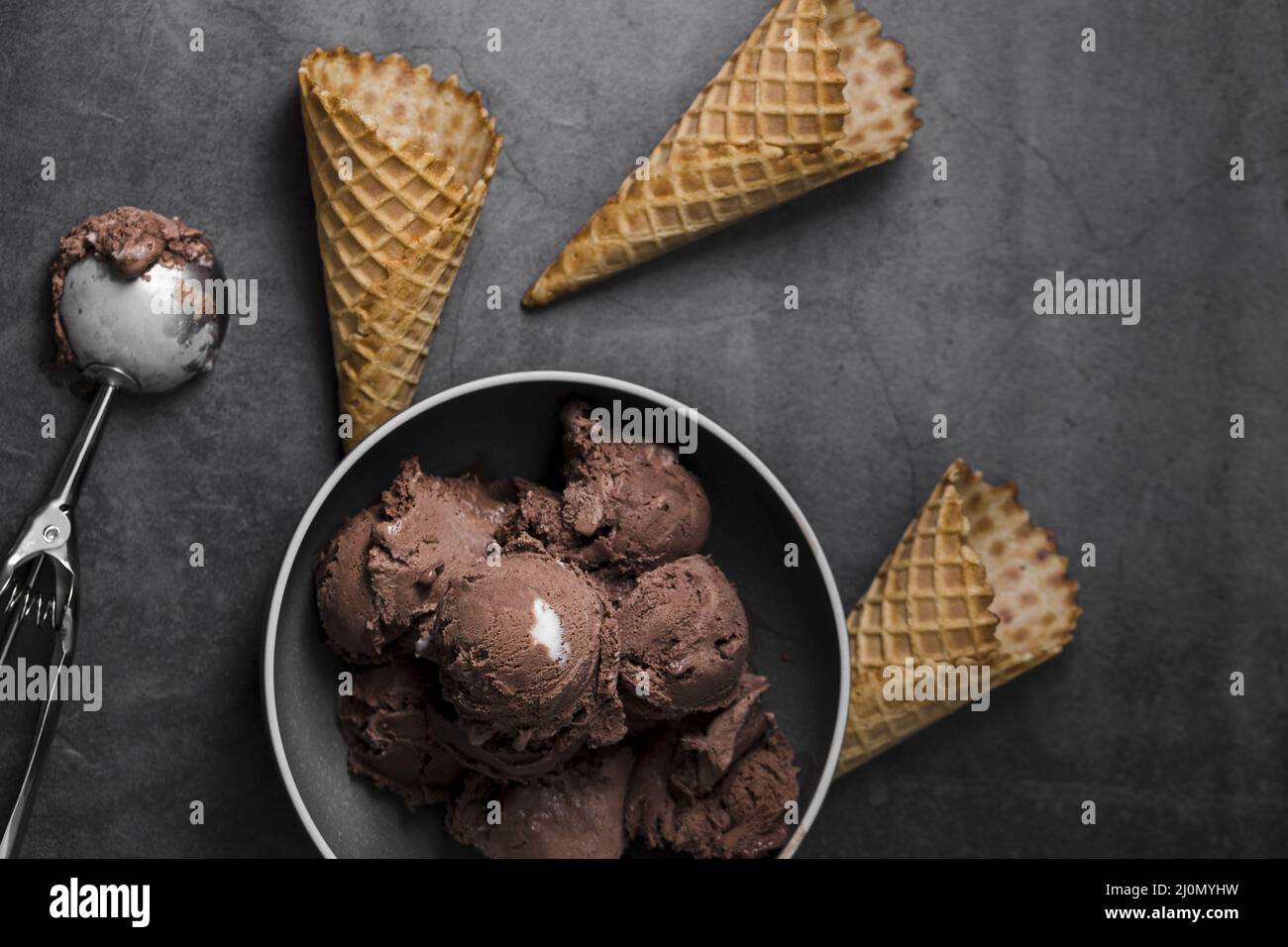 Bowl with ice cream scoops beside ice cream cones Stock Photo