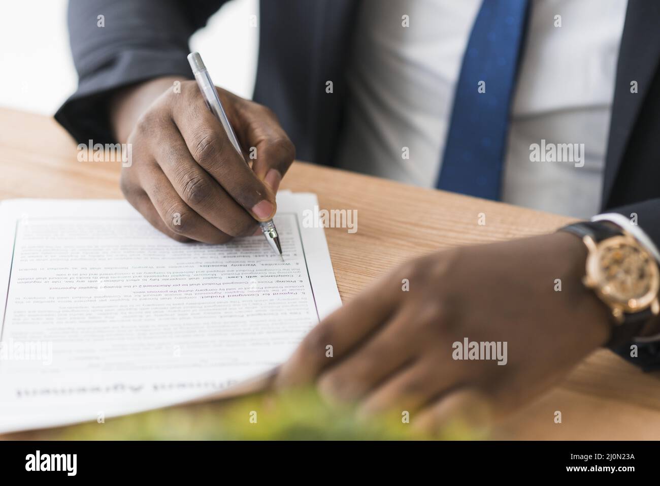 Crop ethnic businessman signing papers Stock Photo