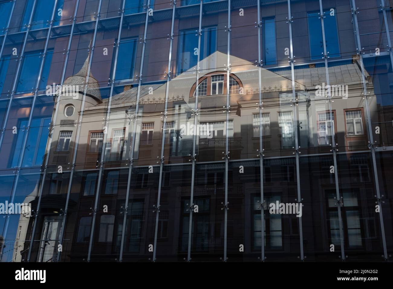 Old architectural building reflection in a new glass and aluminum wall Stock Photo