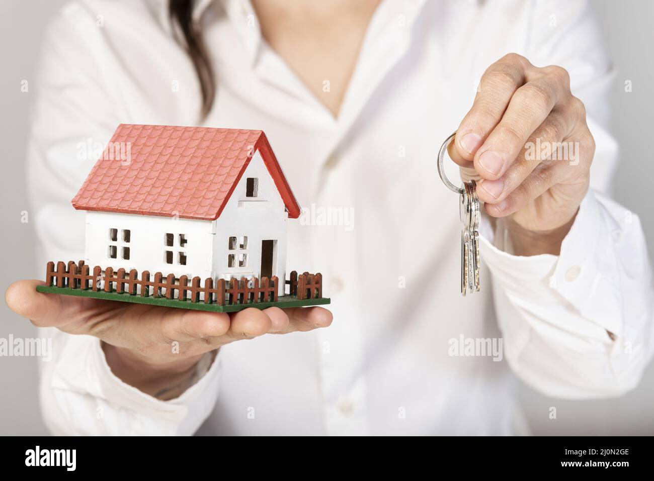 Female holding a toy model house and keys Stock Photo