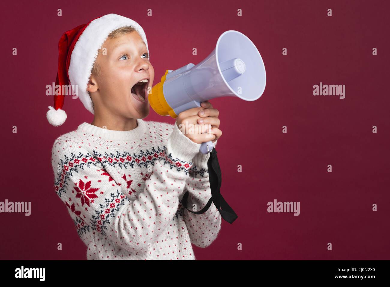 Christmas boy shouting through megaphone Stock Photo