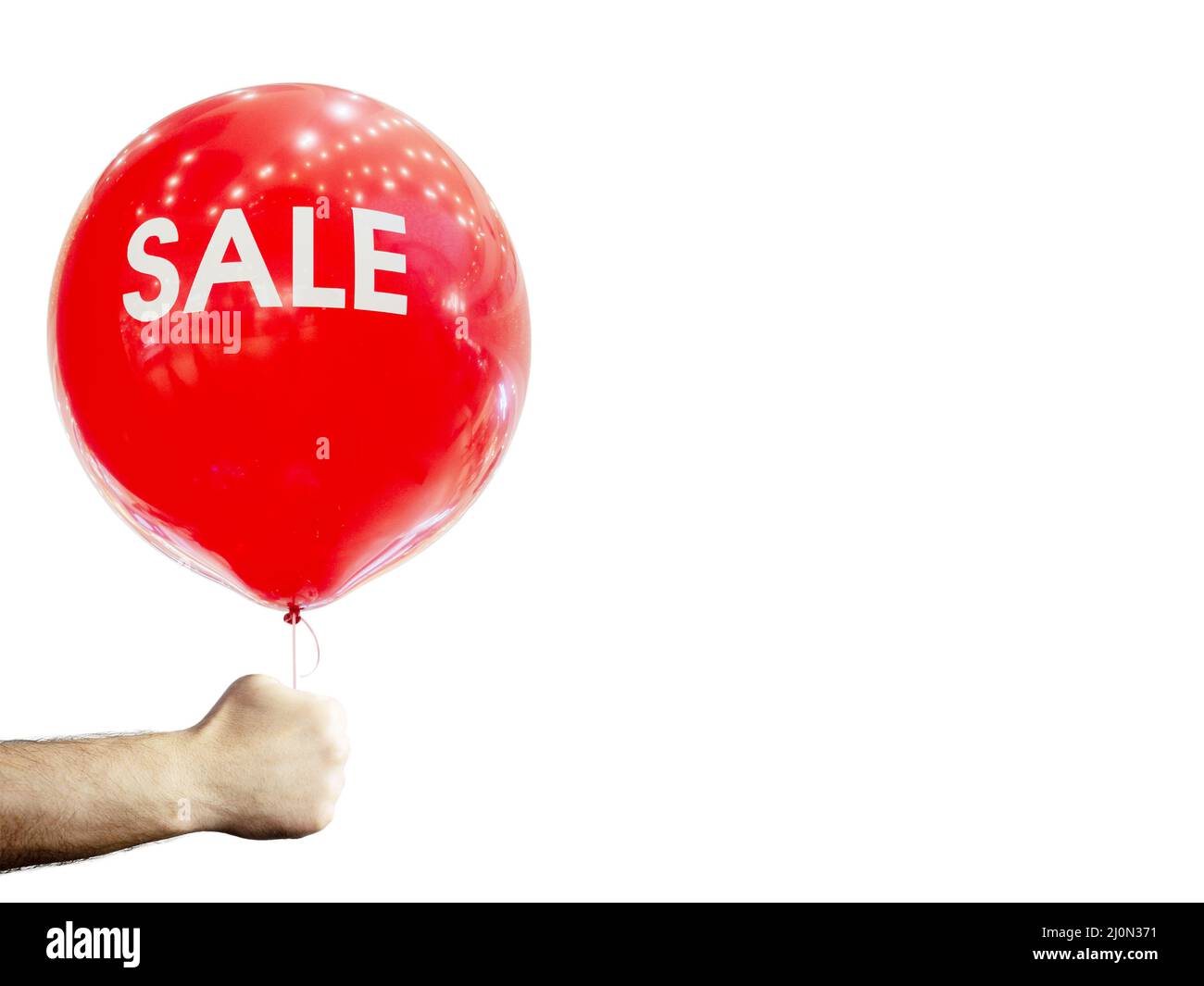A man's hand holds a red inflatable ball with the inscription sale. On an isolated white background. Stock Photo