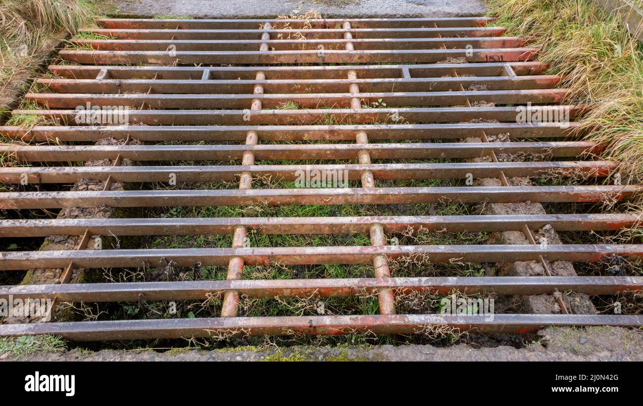 Close up of a rust cattle grid on a farm road Stock Photo