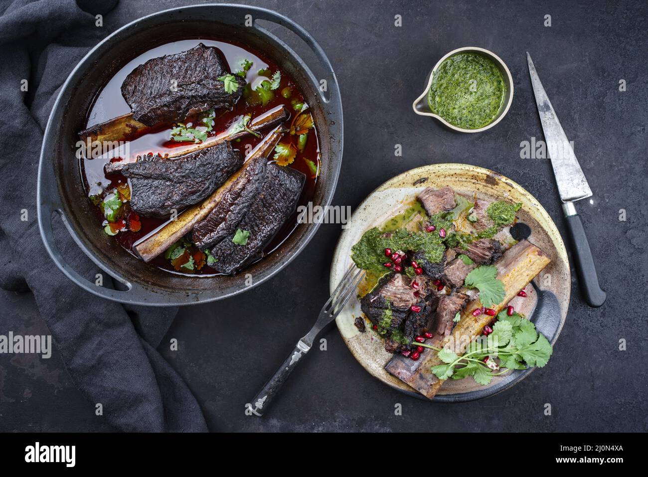 Traditional braised chuck beef ribs in red wine sauce and chimichurri