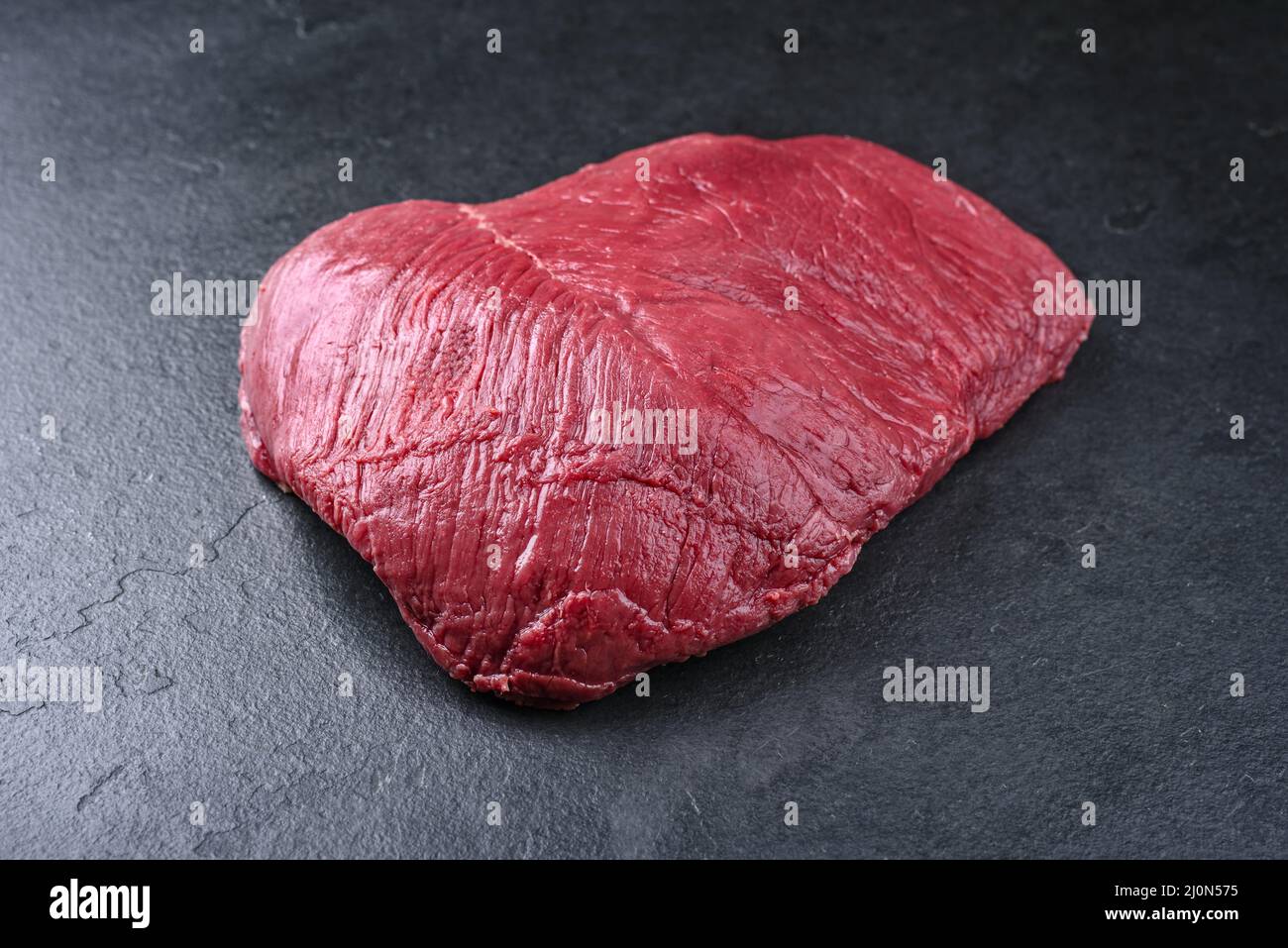 Raw dry aged bison beef rump steak piece as close-up  on black background with copy space Stock Photo