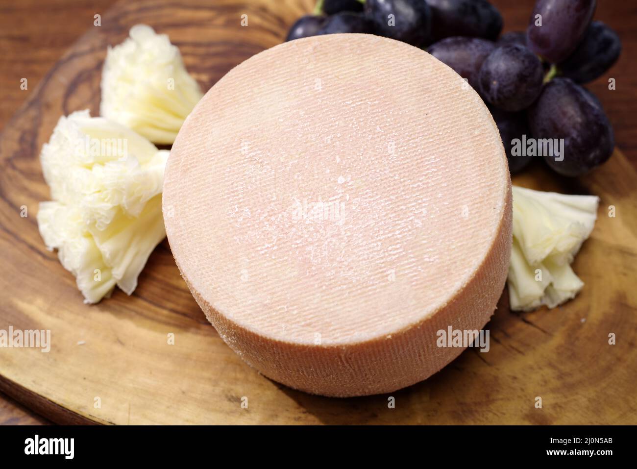 https://c8.alamy.com/comp/2J0N5AB/traditional-tete-de-moine-aged-mountain-cheese-of-the-alps-offered-with-grapes-on-a-wooden-board-2J0N5AB.jpg