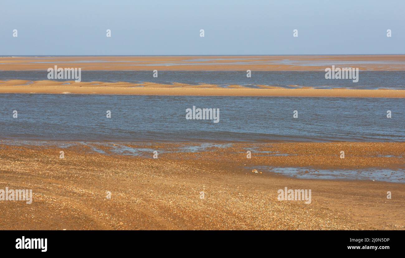 A view from the beach over The Run to the harbour with sand banks following an ebb tide at Wells-Next-the-Sea, Norfolk, England, United Kingdom. Stock Photo