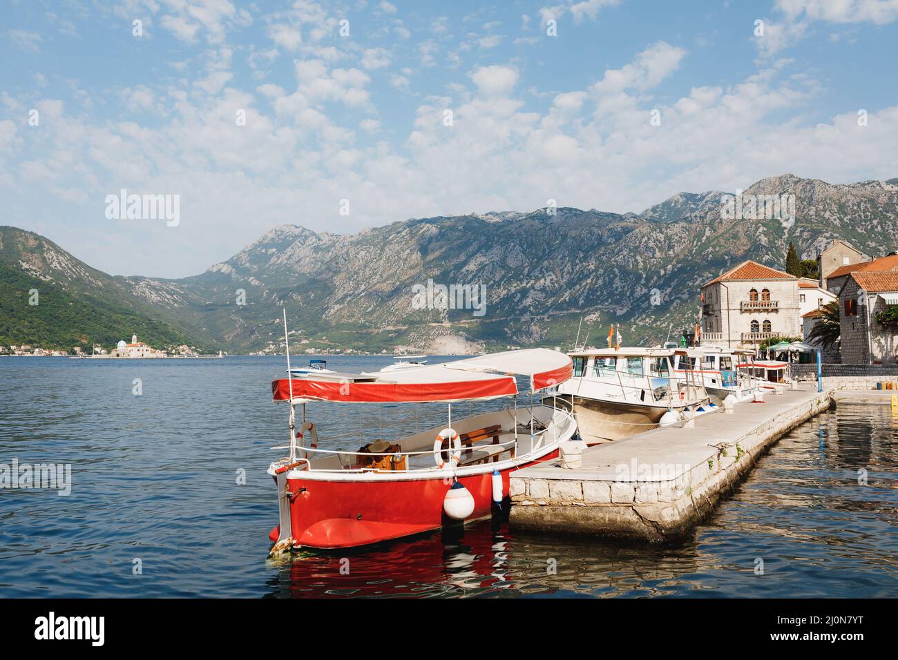Row of boats are moored at the pier in the Kotor Bay off the coast of Perast. Montenegro Stock Photo