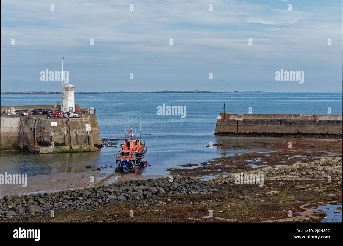 The Shannon Class Lifeboat being launched using its Tracked launch Vehicle approaching the harbour Entrance at Seahouses. Stock Photo