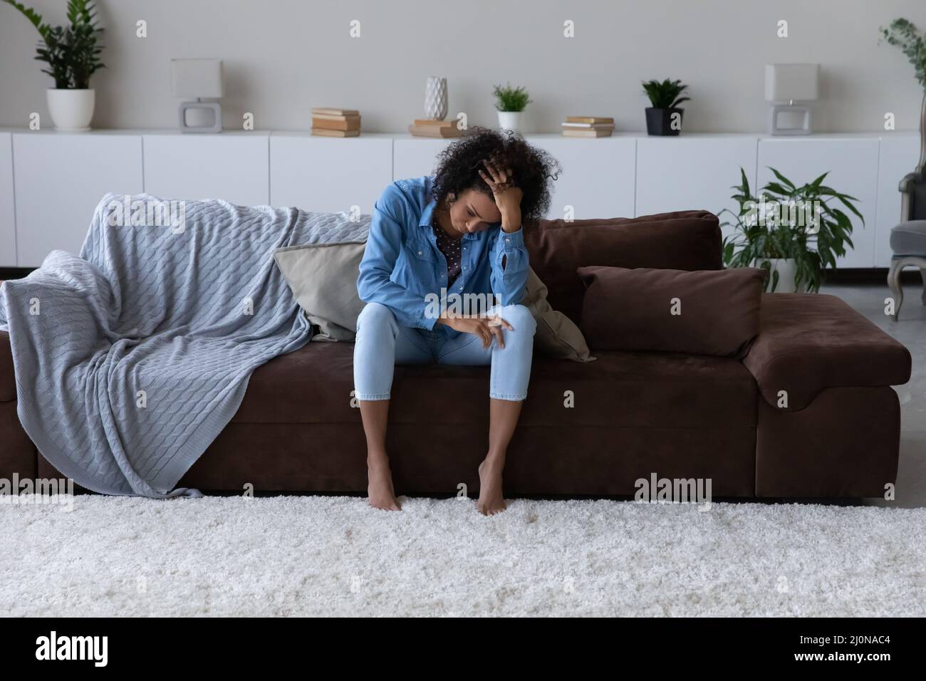 Depressed exhausted young African woman feeling stress Stock Photo