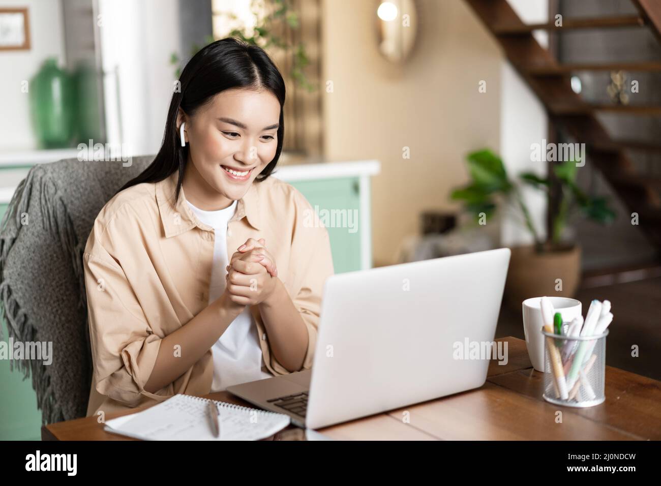 Smiling woman talks online on webinar, video chatting, having conference with work colleagues from home, working remotely Stock Photo
