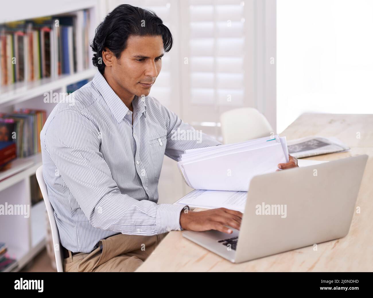 Its hard to stay off the internet. Cropped side of a handsome businessman working from home. Stock Photo