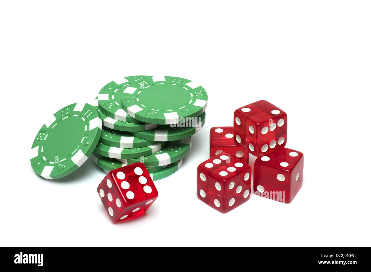 Close up of five stacked red gambling dice in front of green poker chips as concept for casino game on white background Stock Photo