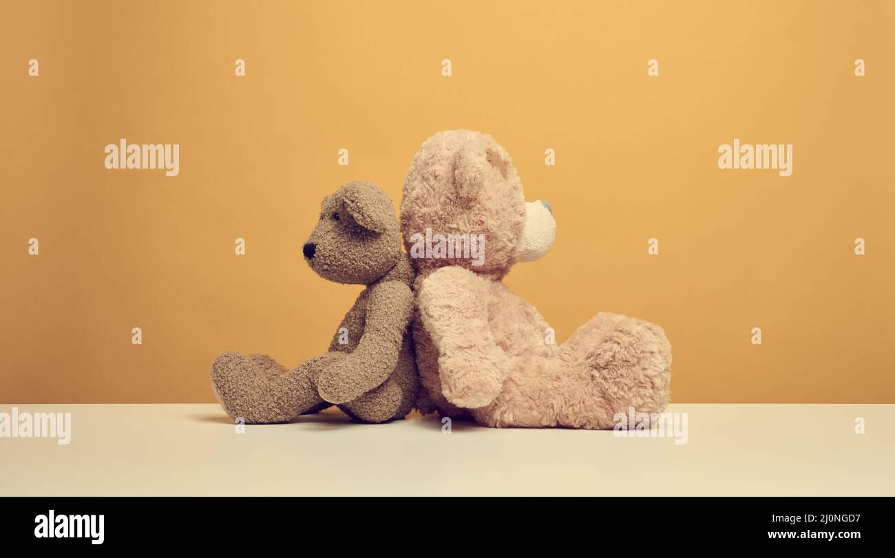 Two cute brown teddy bears sitting on a yellow background, childrens ...