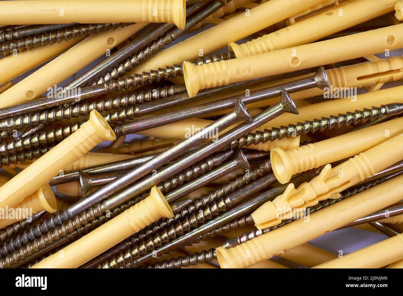 Bunch of tapping construction screws with plastic dowels for fixture. Selective focus. Close-up. Stock Photo