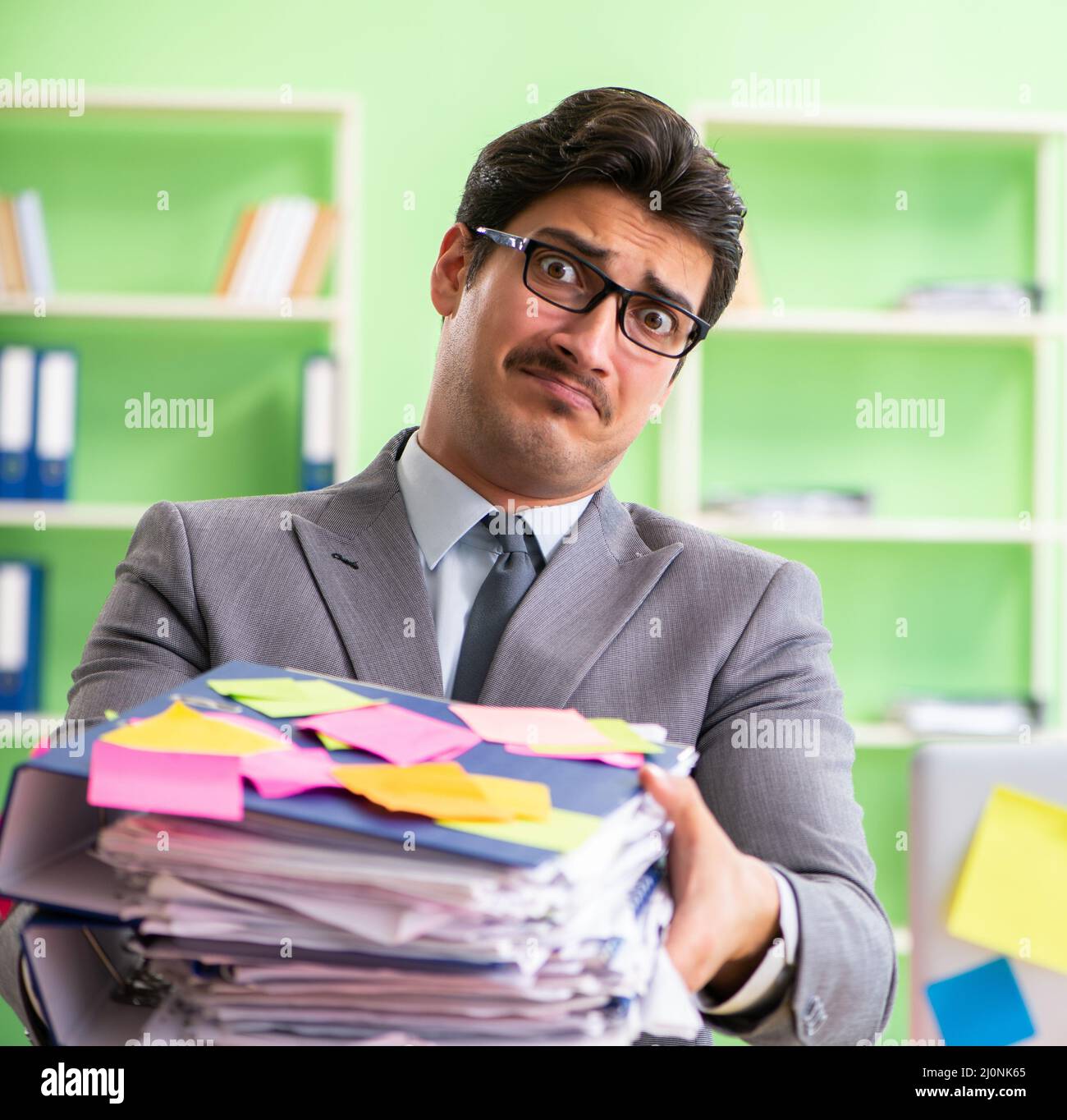 Businessman unhappy with many conflicting priorities sitting in Stock Photo