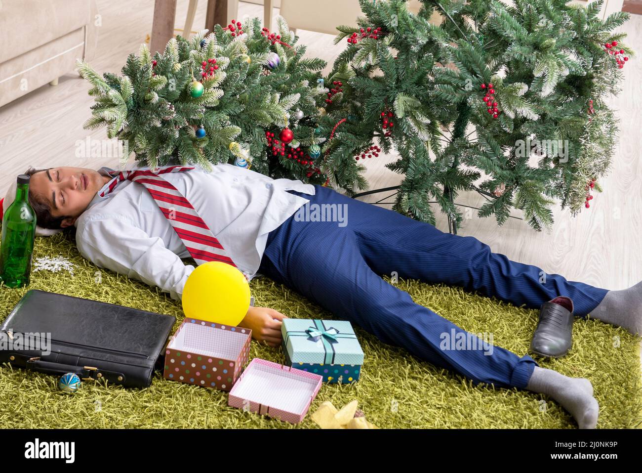 Young handsome employee celebrating Christmas at workplace Stock Photo