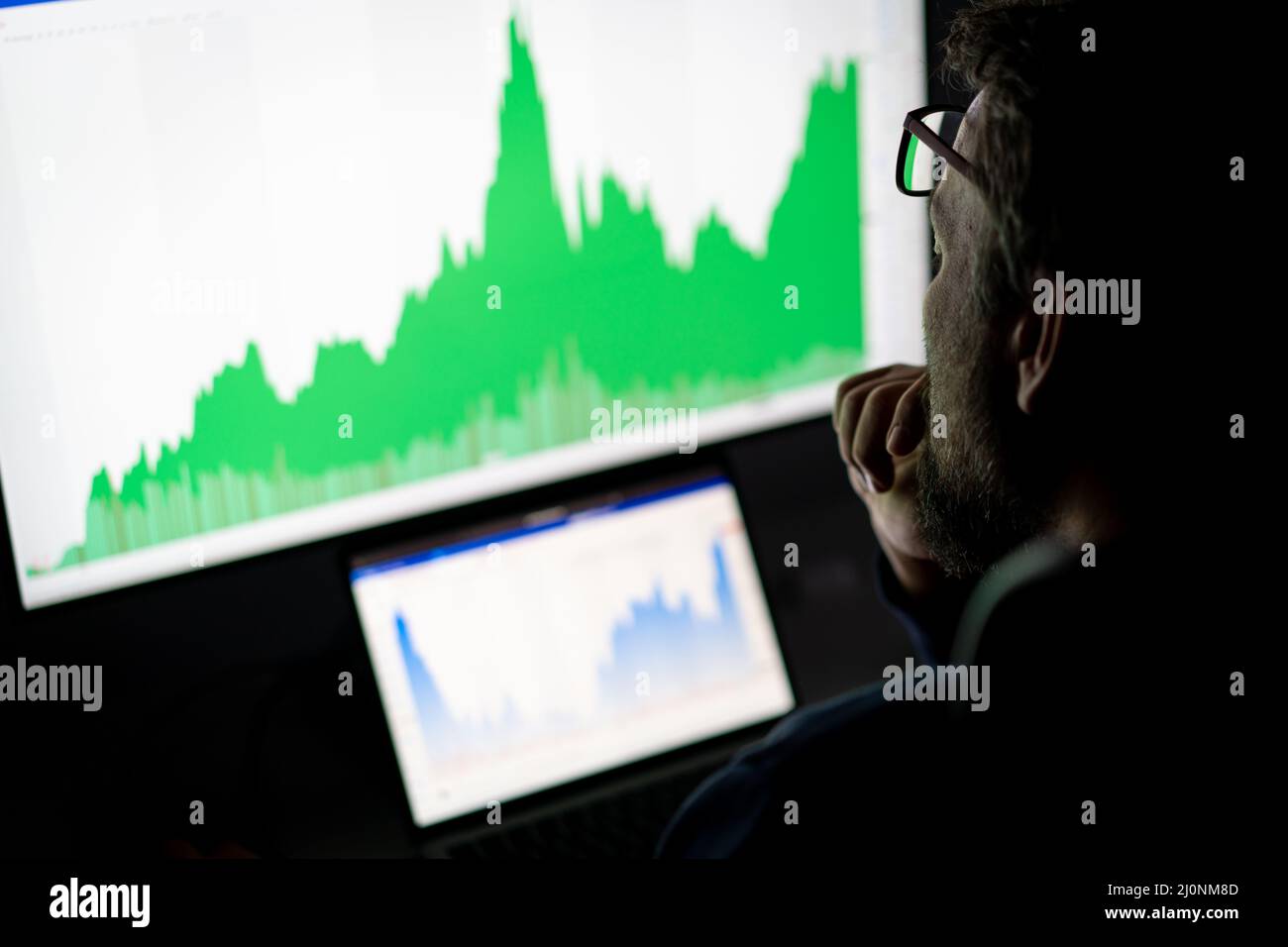 Crypto trader investor analyst looking at computer screen analyzing financial graph data on pc Stock Photo