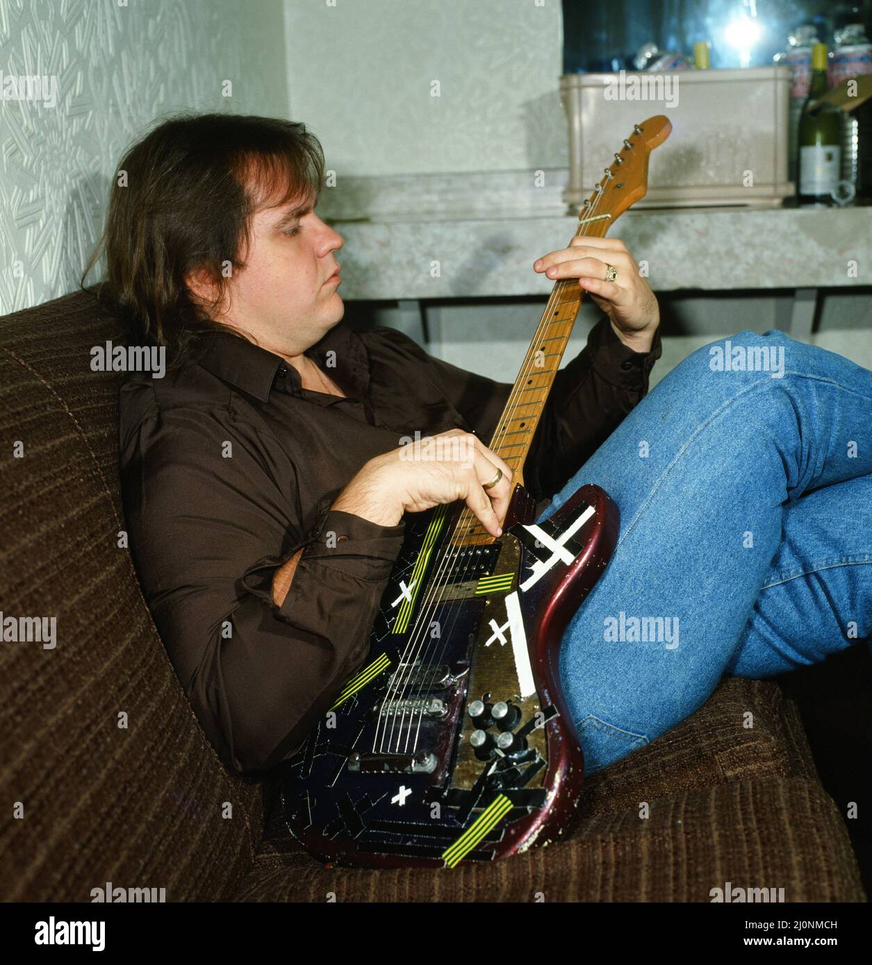 Musician Meat Loaf playing his guitar. September 1983 Stock Photo Alamy
