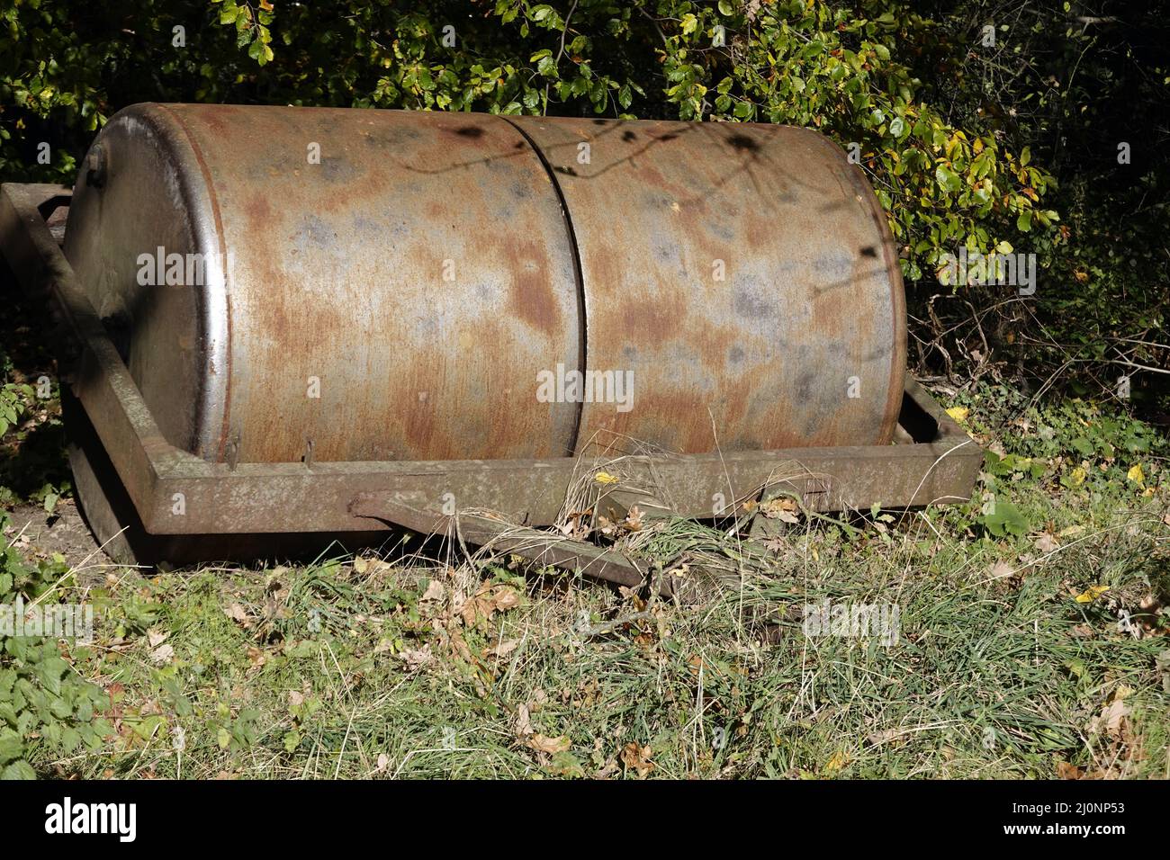 Heavy, agriculturally used iron roller, parked at the edge of the forest Stock Photo