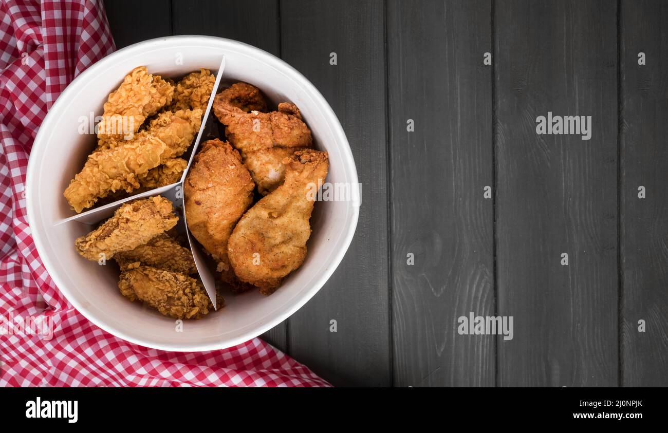 Top view fried chicken bucket with copy space kitchen towel. High quality and resolution beautiful photo concept Stock Photo