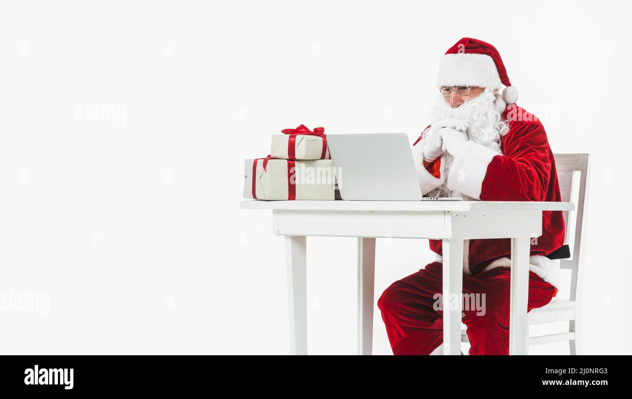 Santa claus looking laptop screen . High quality and resolution beautiful photo concept Stock Photo