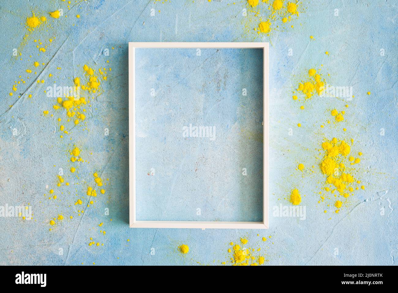 Yellow color powder around the white border frame on painted wall. High quality and resolution beautiful photo concept Stock Photo
