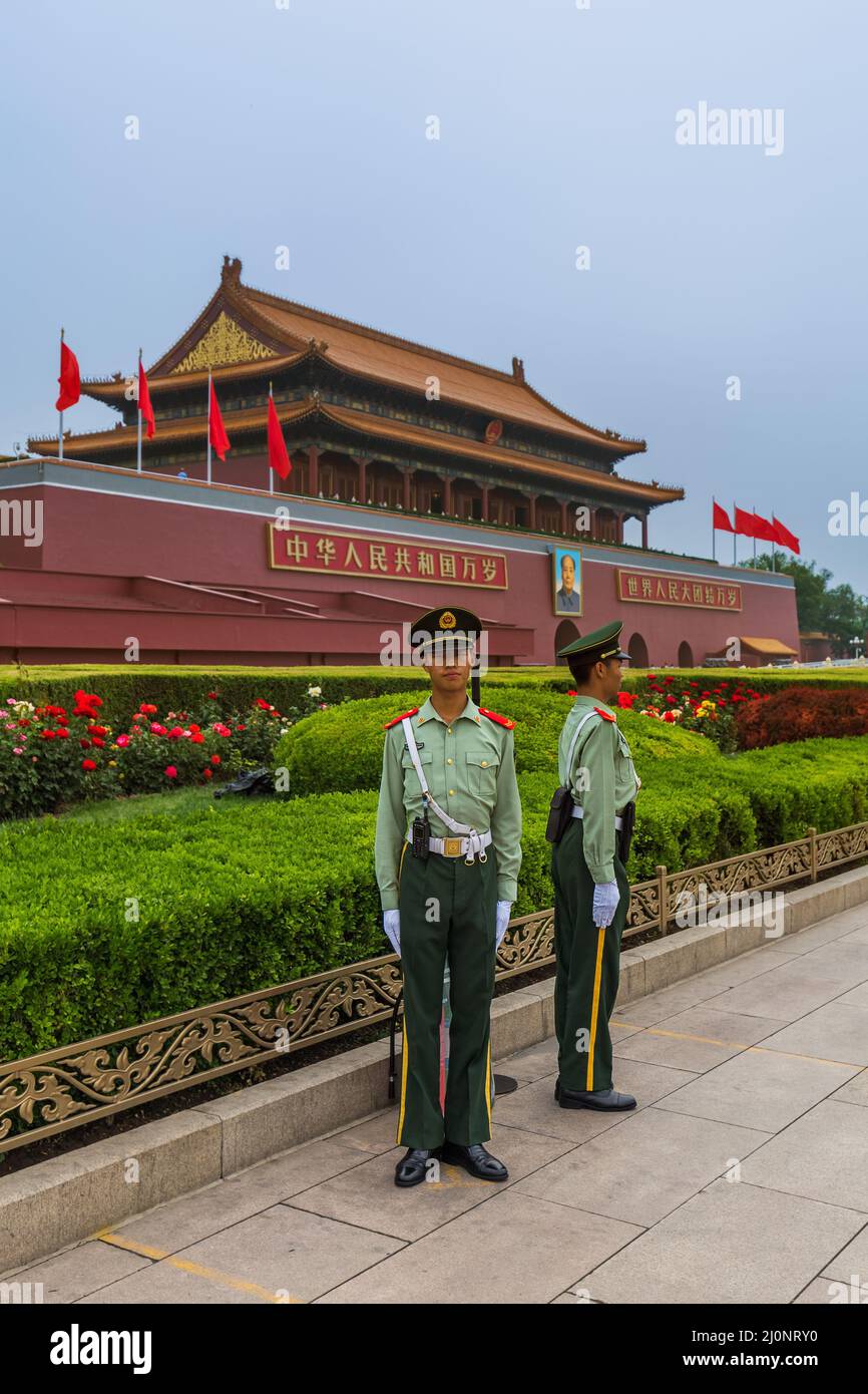 Beijing, China - May 16, 2018: Policeman near Mao Tse Tung Tiananmen Gate in Gugong Forbidden City Palace. Chinese Sayings on Ga Stock Photo