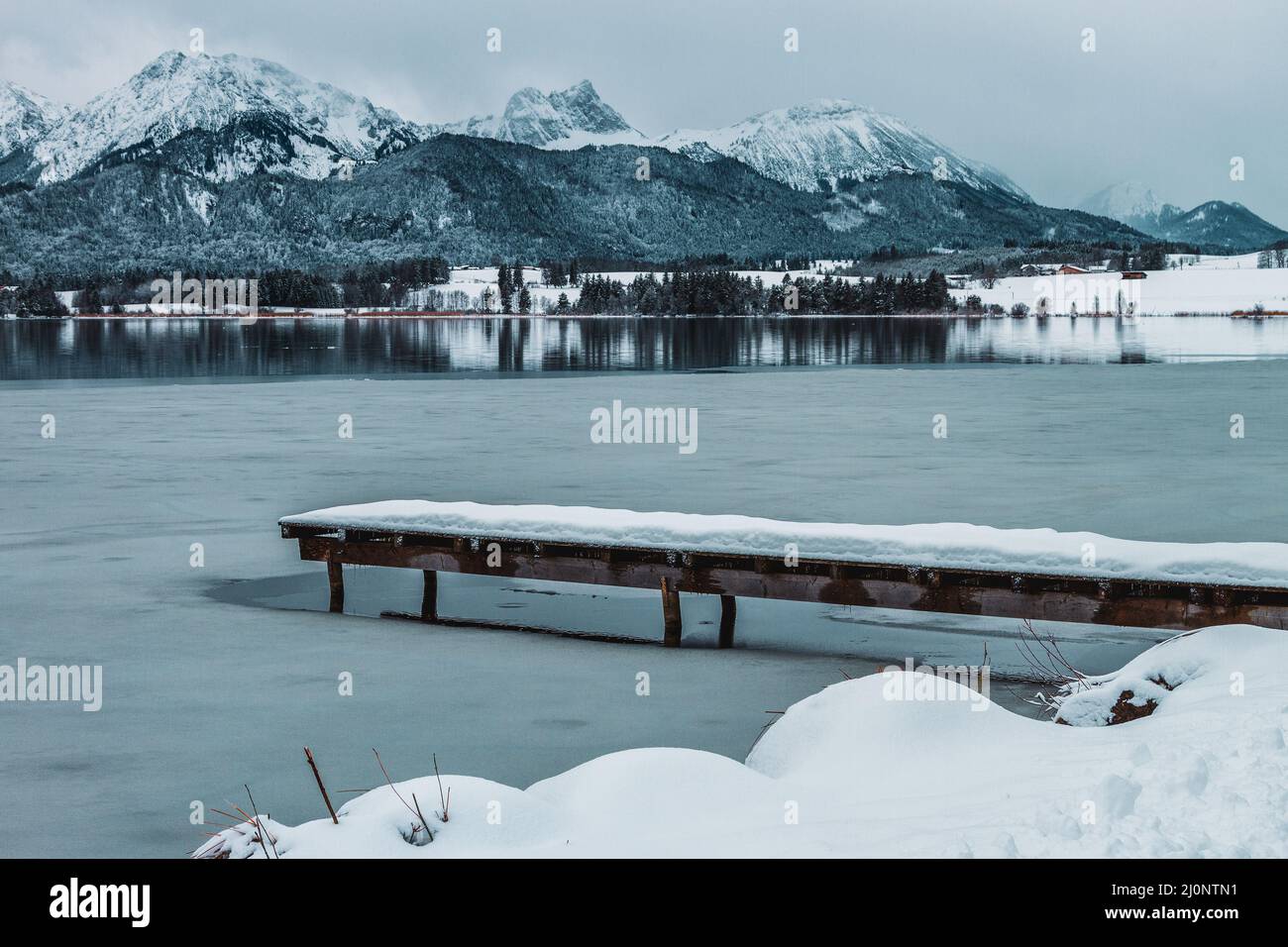 The Hopfensee with the AllgÃ¤u Alps in winter. Germany. Stock Photo