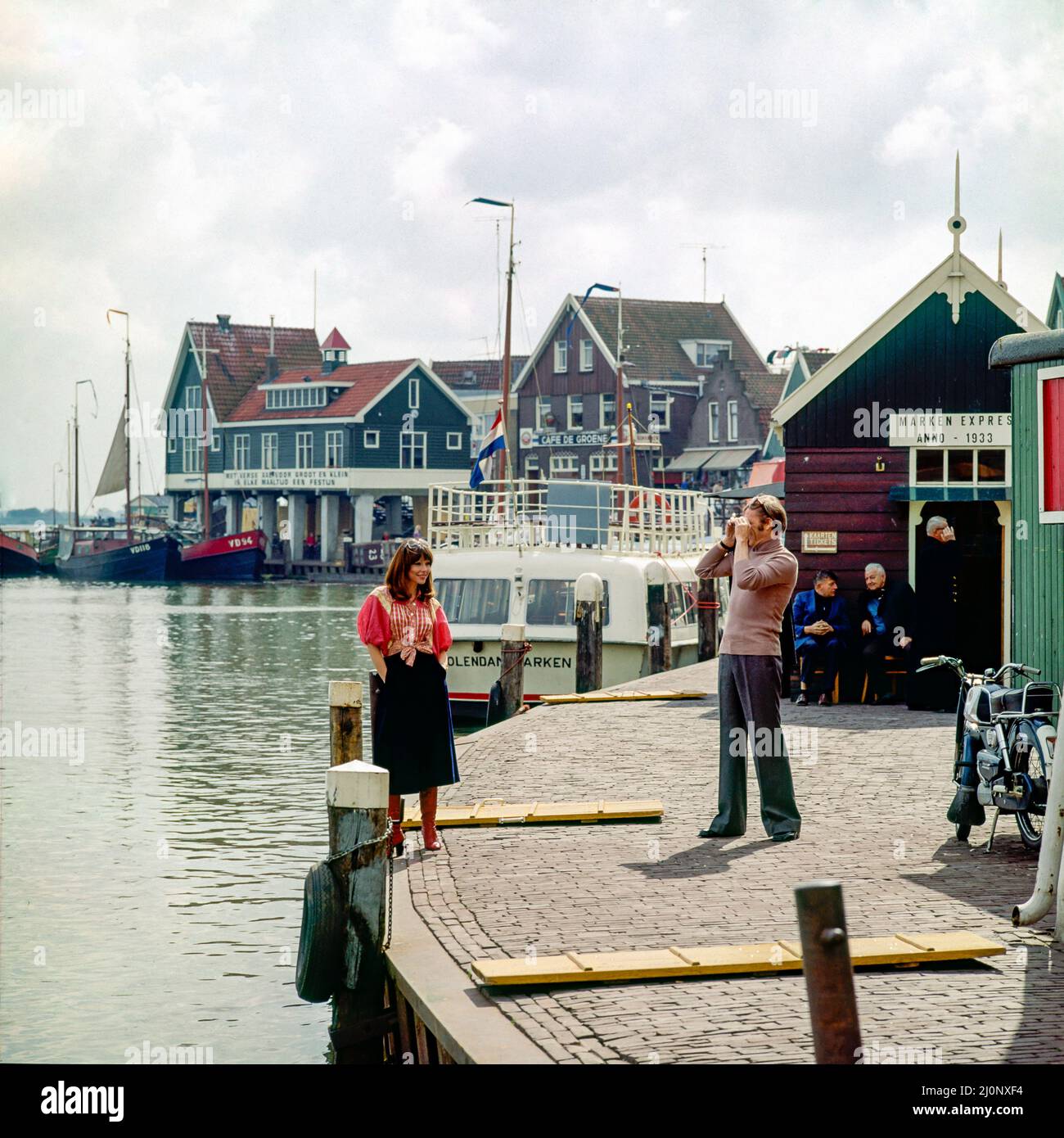 Vintage Netherlands 1970s, couple of middle aged tourists taking pictures, Marken harbour, Waterland, Northern Holland, Europe, Stock Photo