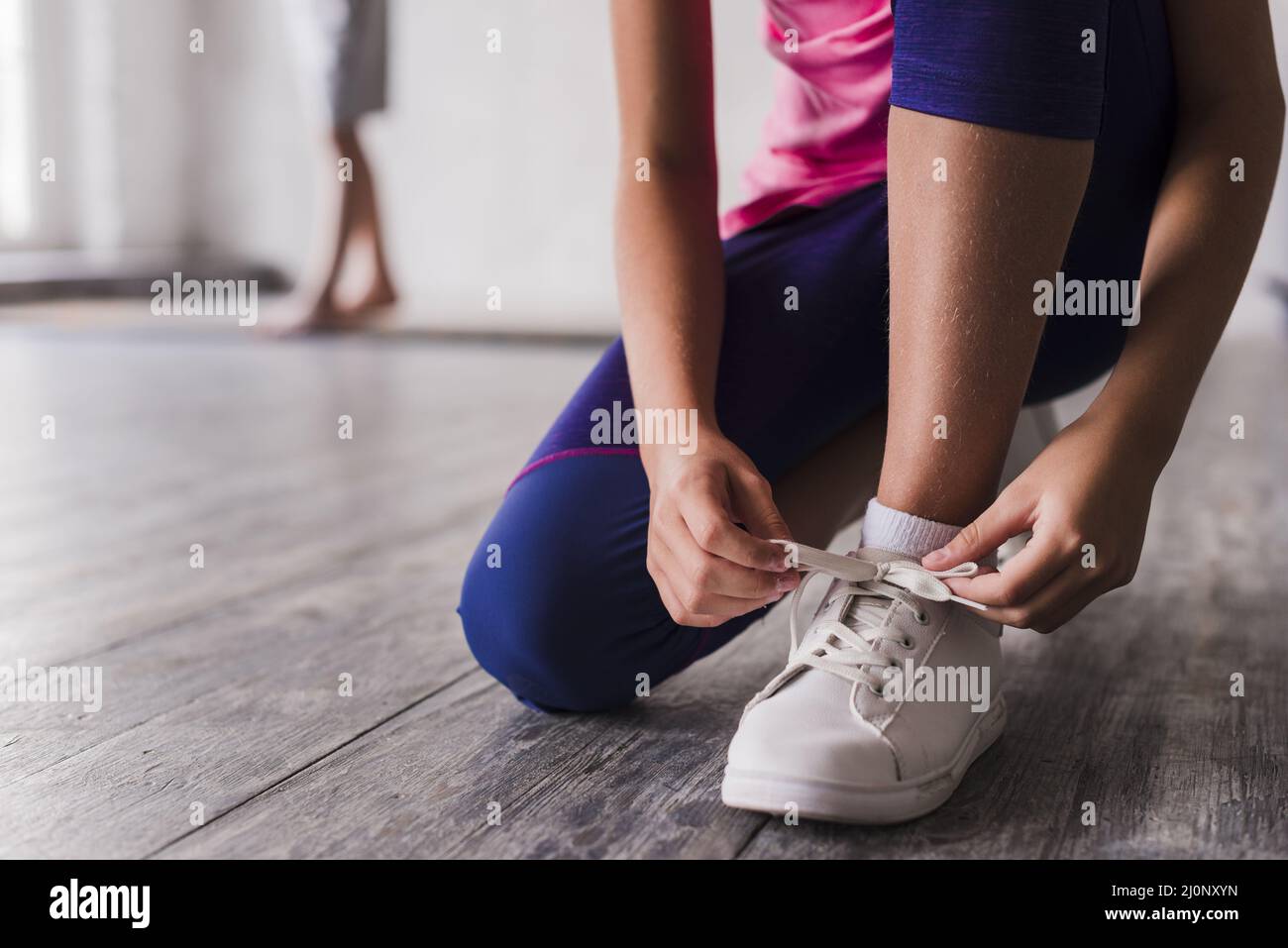 Low section girl tying shoelace white shoes. High quality and resolution beautiful photo concept Stock Photo