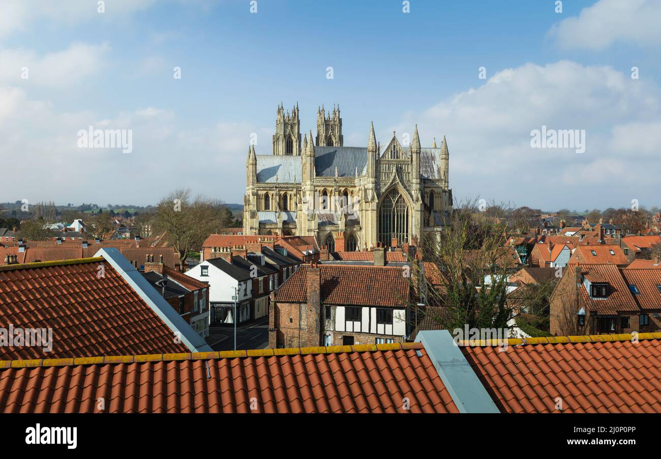 Elevated view over rooftops of ancient minster, church, under bright blue sky with clouds in spring in Beverley, Yorkshire, UK. Stock Photo