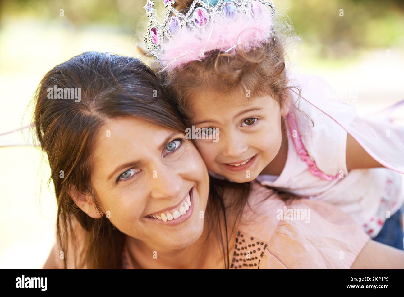 My little princess. Cropped shot of a beautiful woman and her daughter playing outdoors. Stock Photo