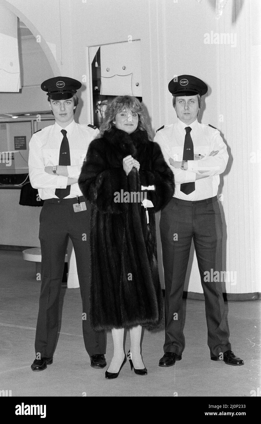 Harrods sale gets underway in Knightsbridge, London. Sara Ford wearing the £55,000 Sable fur coat from Russia, reduced to £33,000, under the watchful eye of the security men . 7th January 1983. Stock Photo