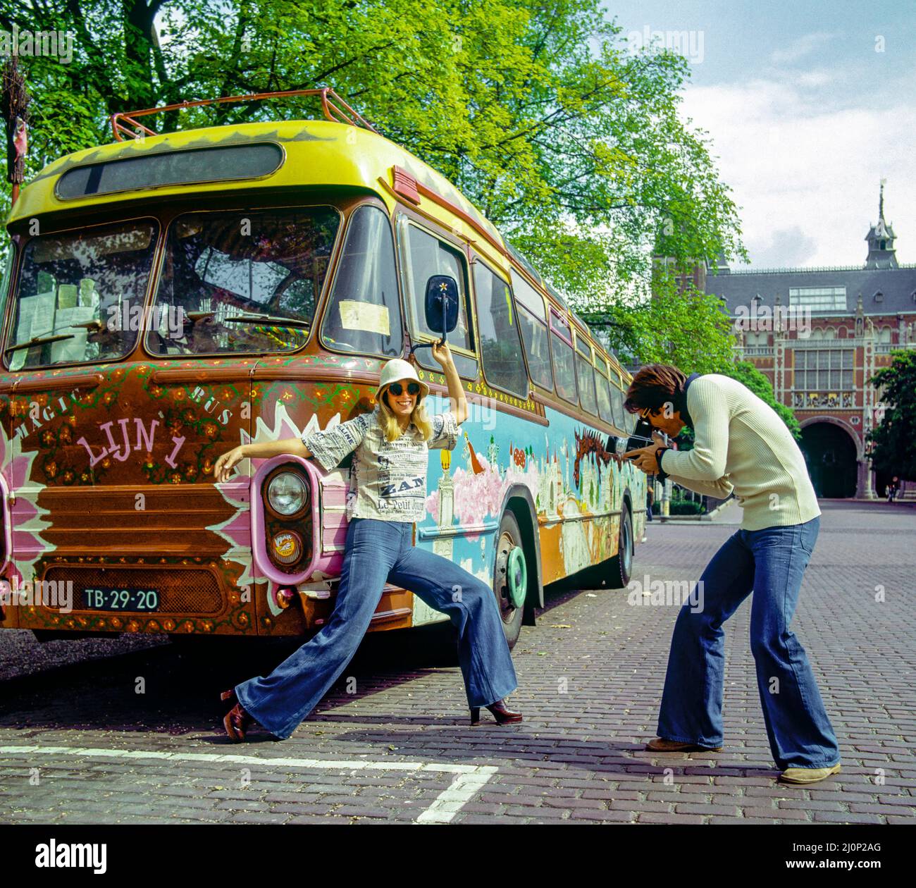Vintage Amsterdam 1970s, couple taking funny pictures, hippy styled decorated bus, Holland, Netherlands, Europe, Stock Photo