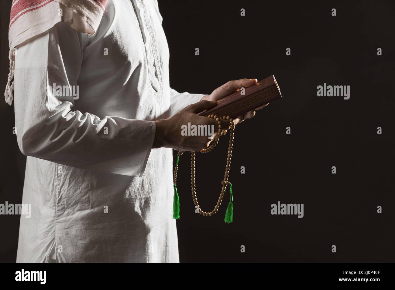Man traditional arabic clothes holding quran. High quality and resolution beautiful photo