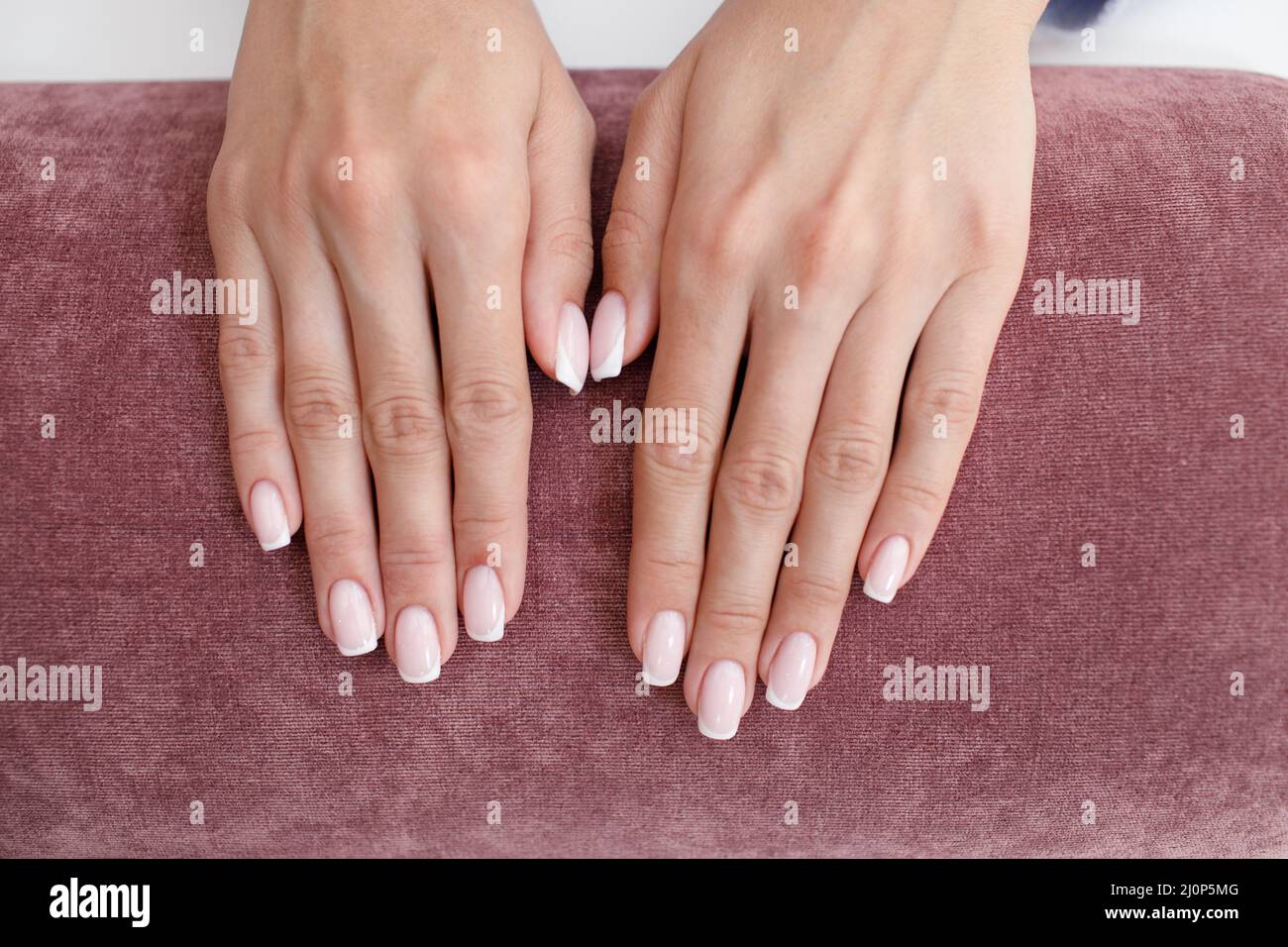 Female hand fingers nails with manicure after nail salon procedure