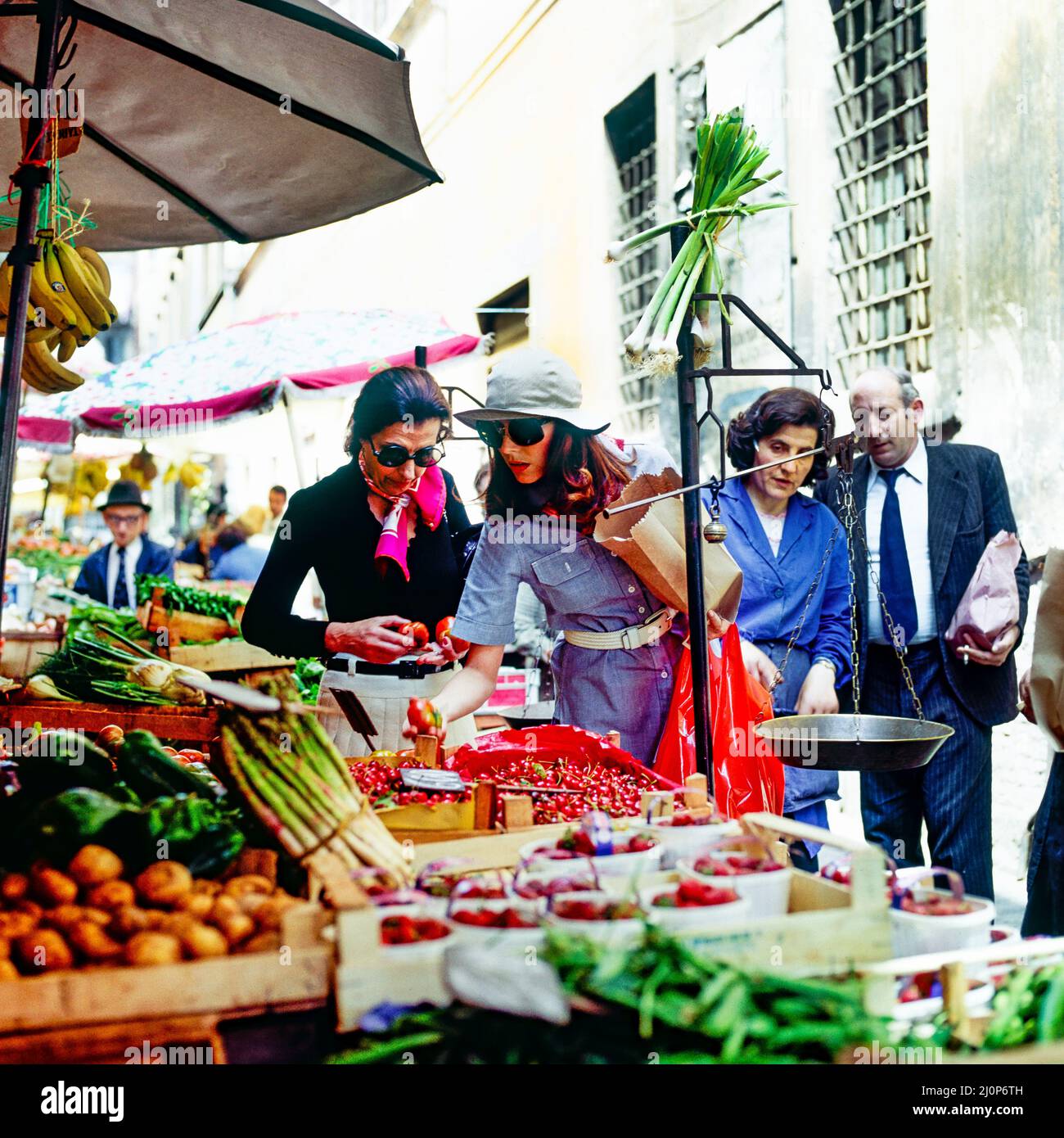 Vintage Rome 1970s, elegant woman and people shopping for food, street market, Italy, Europe, Stock Photo