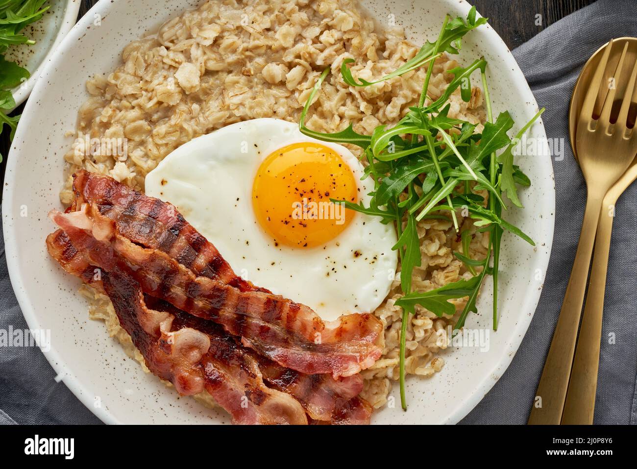 Oatmeal, fried egg and fried bacon. Balance of proteins, fats