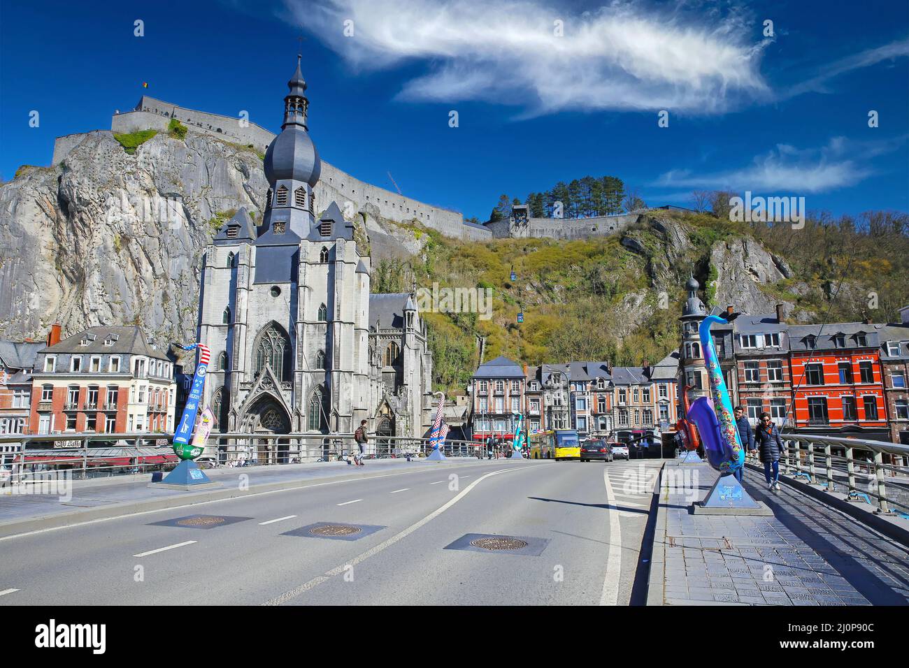 Dinant, Belgium - March 9. 2022: View over bridge on ancient colorful cityscape, medival gothic church, rock with citadel against blue winter sky, flu Stock Photo