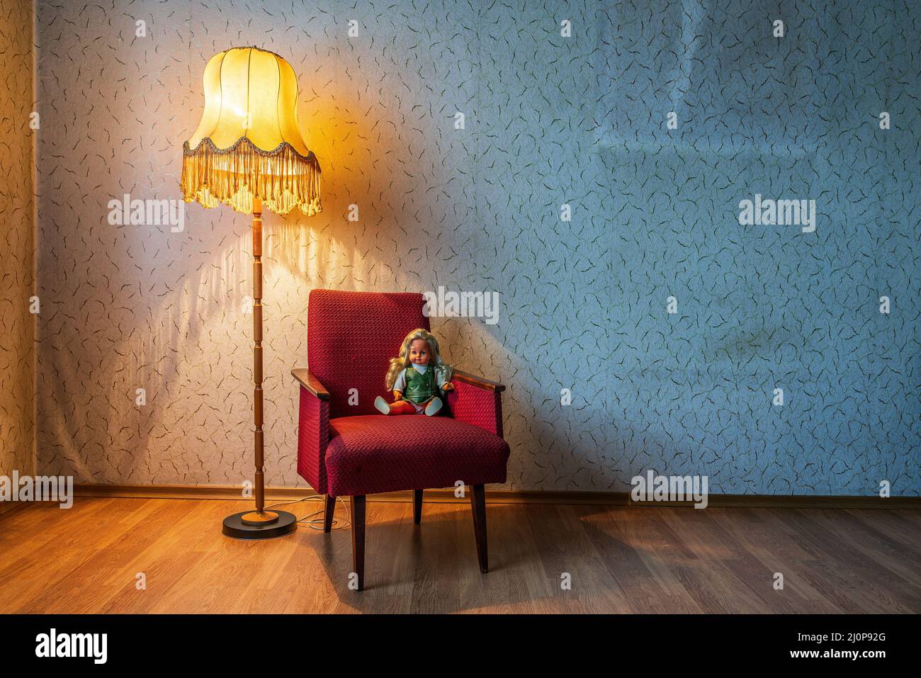 Old floor lamp and armchair with a doll Stock Photo - Alamy