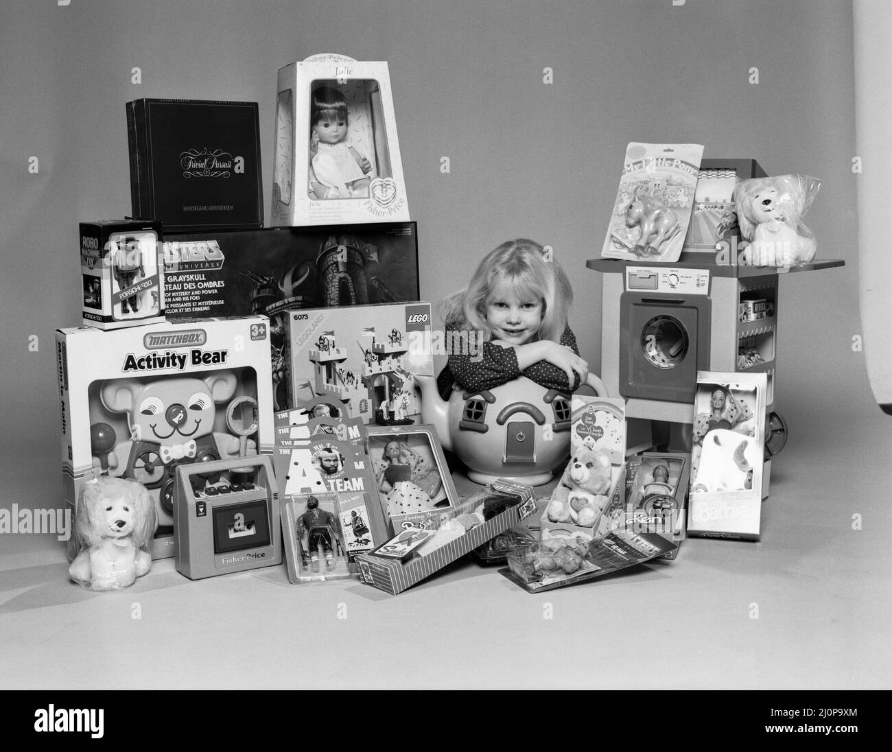 A young girl with a selection of children's toys for Christmas. 6th December 1984. Stock Photo