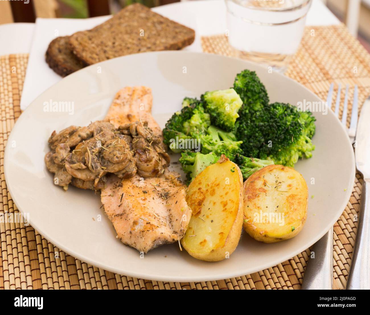 fried river trout fillet with a complex side dish of broccoli, baked