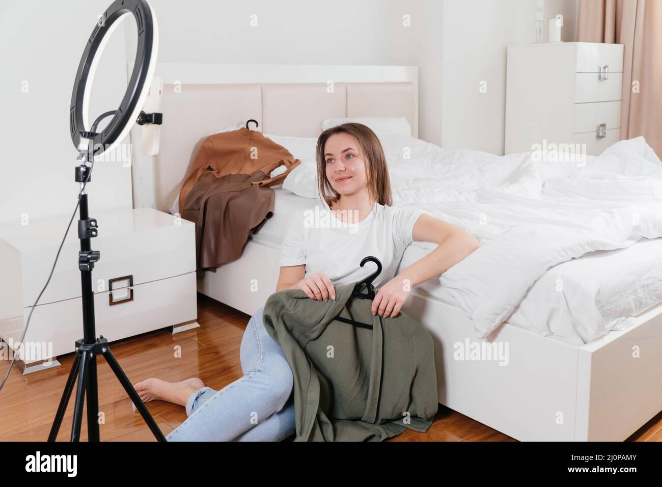 Female Blogger Recording Vlog Video on smartphone At Home Online Influencer On near bed choosing clothes, earthly look Stock Photo
