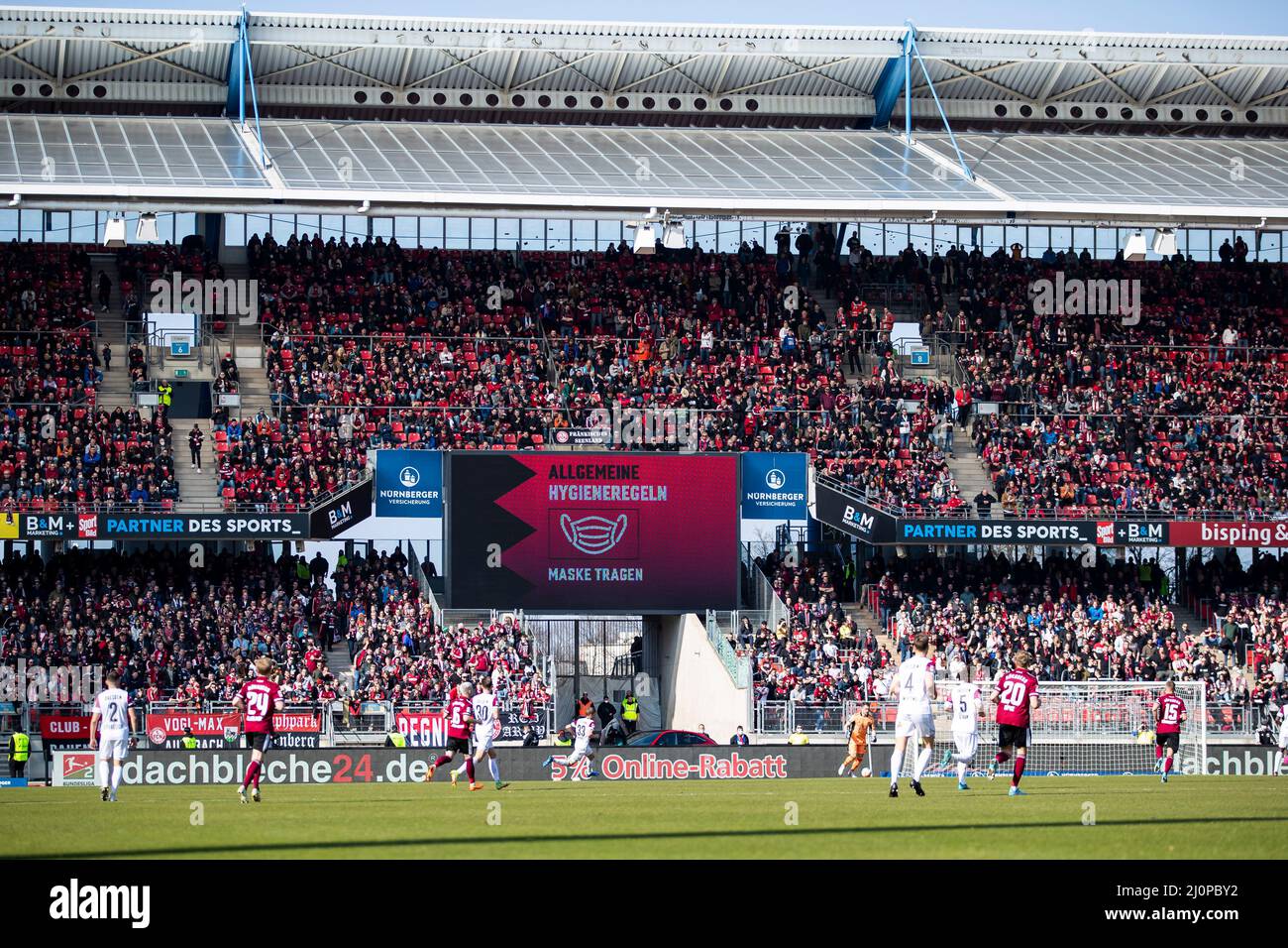Nuremberg, Germany. 20th Mar, 2022. Soccer: 2. Bundesliga, 1. FC Nürnberg - Dynamo Dresden, Matchday 27, Max-Morlock-Stadion. Overview of the crowded Max Morlock Stadium during the match. The scoreboard reads 'Wear mask'. Credit: Tom Weller/dpa - IMPORTANT NOTE: In accordance with the requirements of the DFL Deutsche Fußball Liga and the DFB Deutscher Fußball-Bund, it is prohibited to use or have used photographs taken in the stadium and/or of the match in the form of sequence pictures and/or video-like photo series./dpa/Alamy Live News Stock Photo