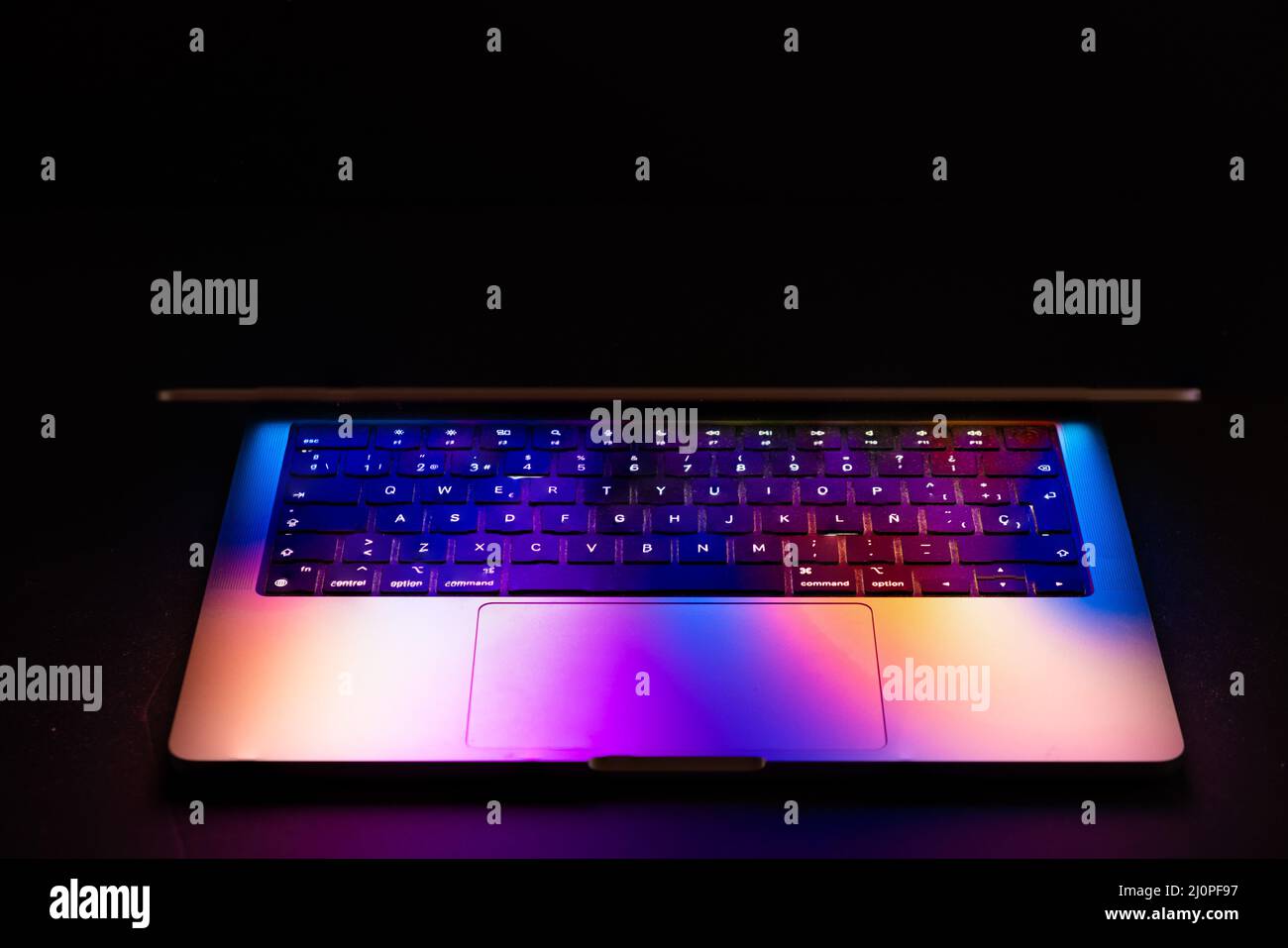 Spain, 03, 20, 2022.Macbook Pro 2021 with glowing colorful reflection. Stock Photo
